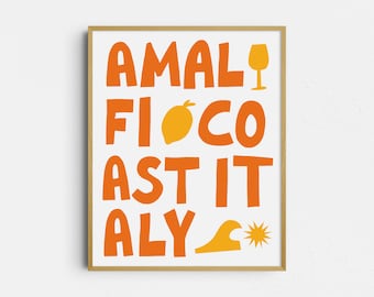May include: A framed art print with the words "AMALFI COAST ITALY" in orange block letters. The print includes illustrations of a wine glass, a lemon, a wave, and a sun, all in shades of orange and yellow. The frame is a light brown color.