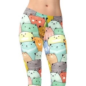 May include: A pair of leggings with a colorful pattern of cartoon cats. The cats are in various shades of green, blue, orange, and pink. The leggings are a great option for yoga, running, or everyday wear.