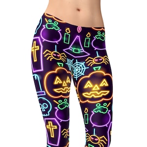 Peut inclure: Leggings à thème Halloween en néon vert, orange et violet avec un motif répété de citrouilles, d'araignées, de chapeaux de sorcières et de pierres tombales.