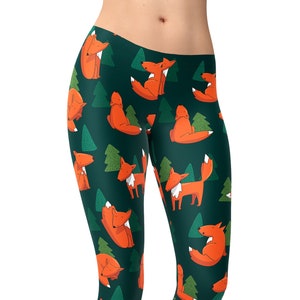 May include: Green leggings with a repeating pattern of orange foxes and green trees. The leggings are shown on a model.