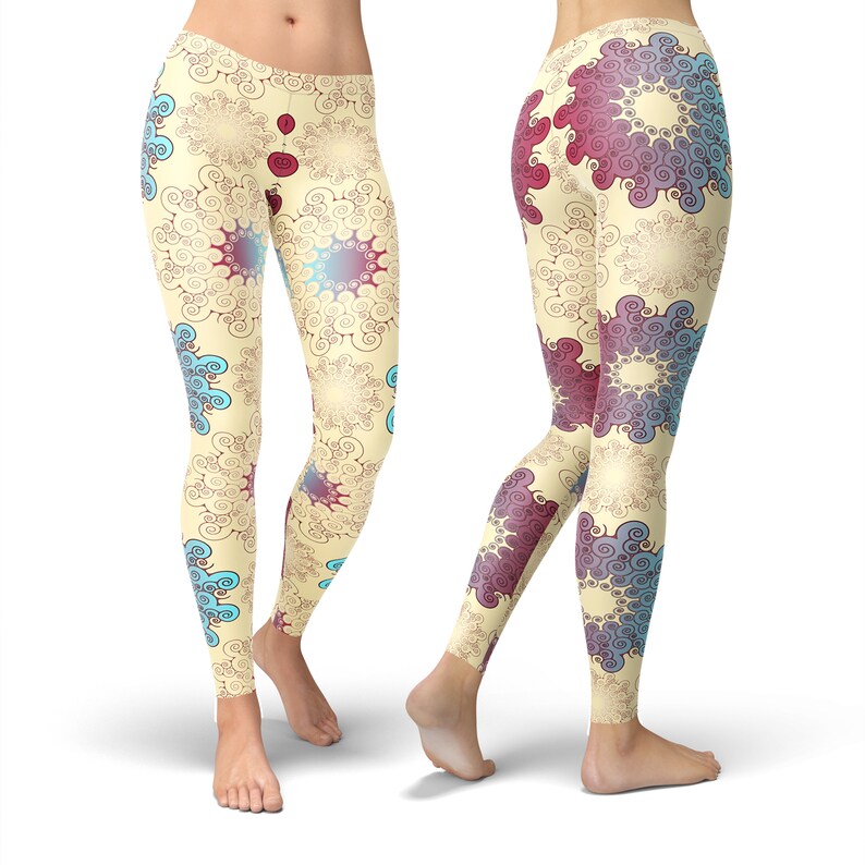 K&ouml;nnte beinhalten: Eine Leggings mit einem farbenfrohen abstrakten Muster aus Spiralen und Kreisen in Blaut&ouml;nen, Rot und Gelb auf cremefarbenem Hintergrund.
