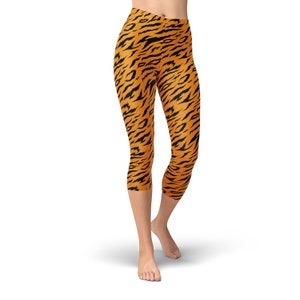 May include: Orange and black tiger print leggings with a high waist and a cropped length.
