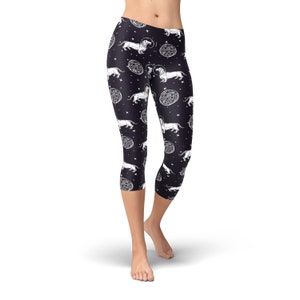May include: Black capri leggings with a white print of dachshunds and celestial bodies.