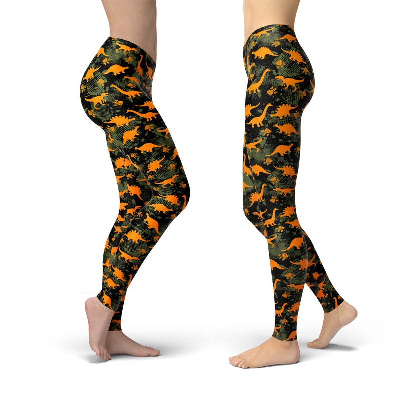 May include: Black leggings with a camouflage pattern featuring orange dinosaur silhouettes.