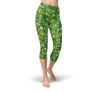 May include: Green capri leggings with a peacock feather pattern. The leggings have a high waist and are made of a stretchy, comfortable fabric.