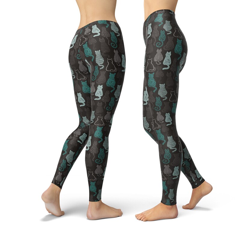 May include: Black leggings with a repeating pattern of stylized cats in teal, gray, and white. The cats are in various poses and designs, creating a playful and whimsical look. The leggings are form-fitting and made of a soft material.