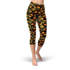 May include: Black and green capri leggings with a pattern of orange dinosaurs.