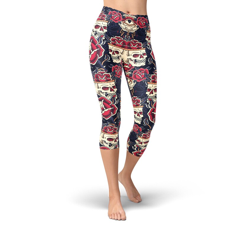 May include: Black capri leggings with a skull and rose print. The print features red roses, white skulls, and a single eye with a lightning bolt.