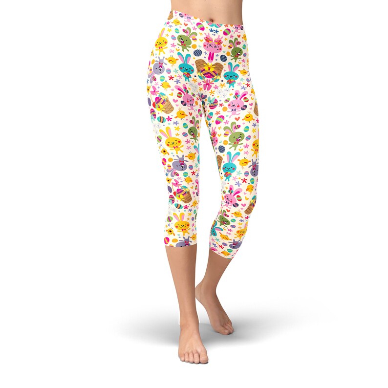 May include: White capri leggings with a colourful Easter-themed pattern featuring bunnies, chicks, and eggs.
