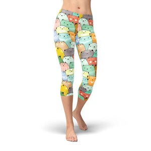May include: Colorful leggings with a pattern of cartoon cats in various colors, including green, blue, yellow, orange, and pink.