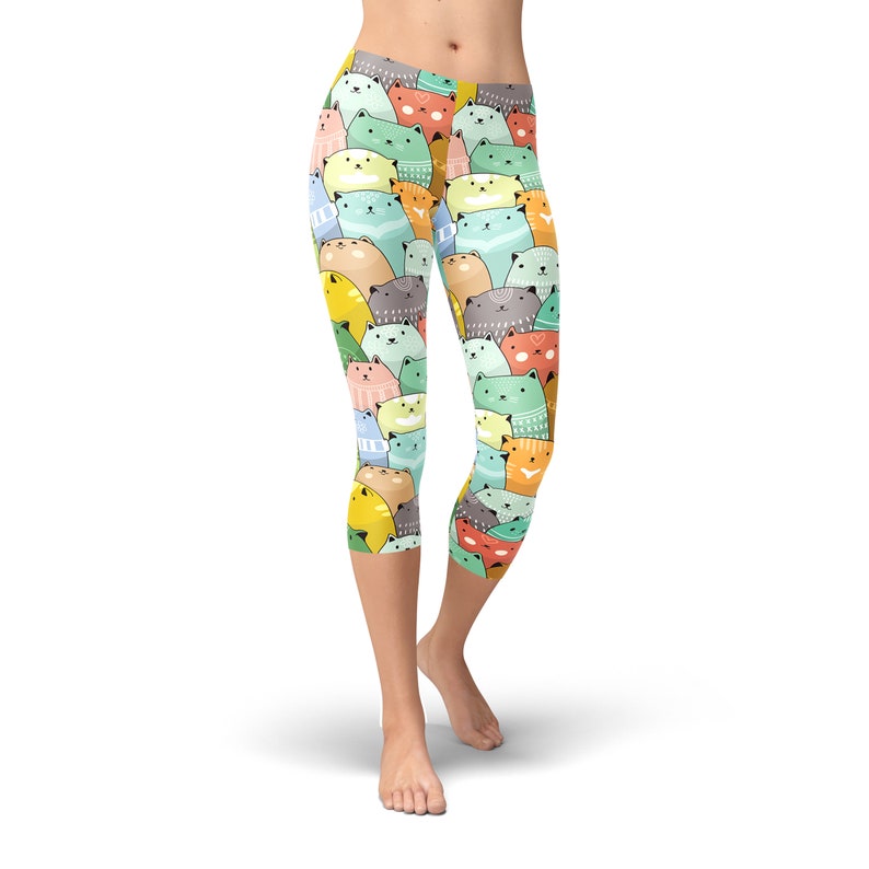 May include: Colorful leggings with a pattern of cartoon cats in various colors, including green, blue, yellow, orange, and pink.