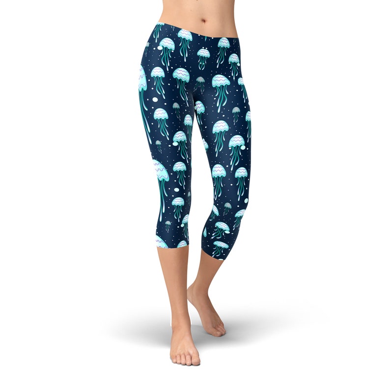 May include: Blue cropped leggings with a repeating pattern of white and blue jellyfish on a dark blue background.