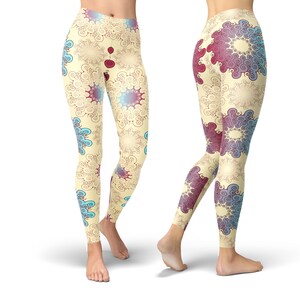 K&ouml;nnte beinhalten: Eine Leggings mit einem farbenfrohen abstrakten Muster aus Spiralen und Kreisen in Blaut&ouml;nen, Rot und Gelb auf cremefarbenem Hintergrund.