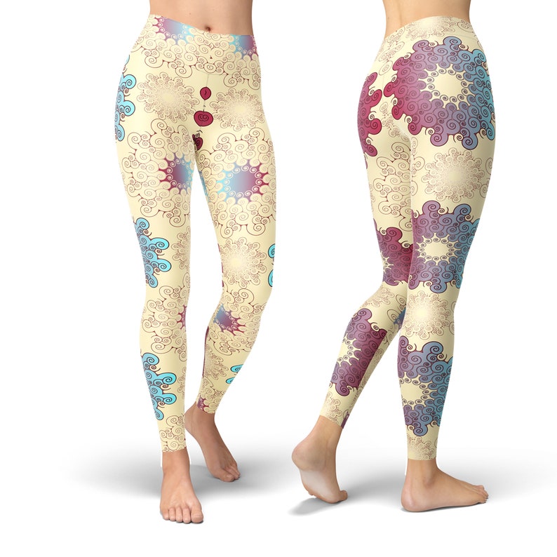 K&ouml;nnte beinhalten: Eine Leggings mit einem farbenfrohen abstrakten Muster aus Spiralen und Kreisen in Blaut&ouml;nen, Rot und Gelb auf cremefarbenem Hintergrund.