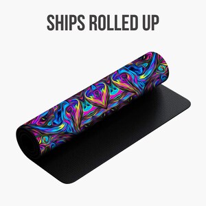 May include: A rolled-up yoga mat with a colorful abstract design featuring swirls of pink, blue, yellow, and green. The mat has a black underside.