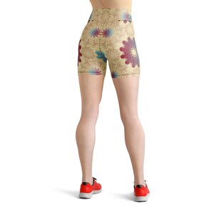 K&ouml;nnte beinhalten: Eine beige Sport-Shorts mit einem bunten Mandala-Muster. Die Shorts haben einen hohen Bund und eine figurbetonte Silhouette.
