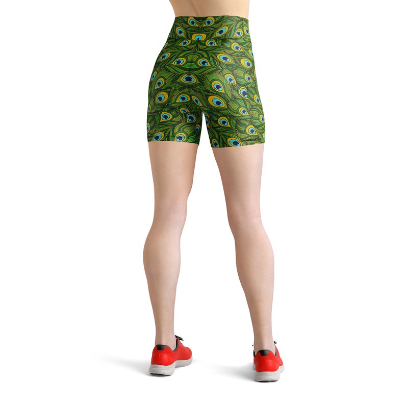 May include: Green athletic shorts with a peacock feather pattern. The shorts are high-waisted and have a tight fit.
