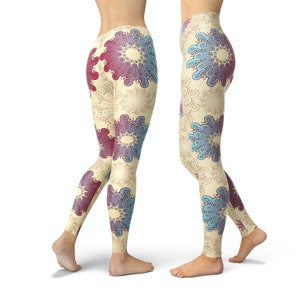 K&ouml;nnte beinhalten: Eine Leggings mit cremefarbenem Hintergrund und einem bunten Muster aus blauen, violetten und roten Wirbeln. Die Leggings ist figurbetont und hat einen hohen Bund.