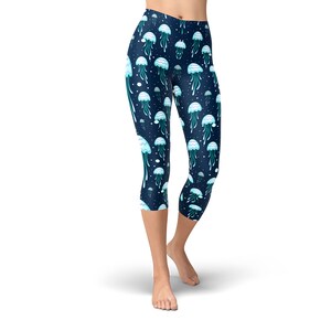 May include: Blue cropped leggings with a pattern of white and blue jellyfish on a dark blue background.