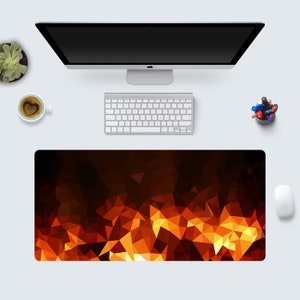 May include: A desk mat with a geometric pattern of orange, yellow, and red triangles. The pattern resembles a fiery blaze.