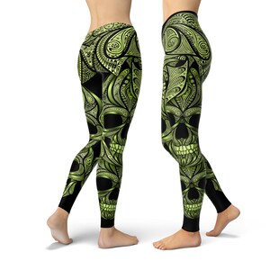 Może przedstawiać: Czarne legginsy z zieloną czaszką i wzorem paisley.