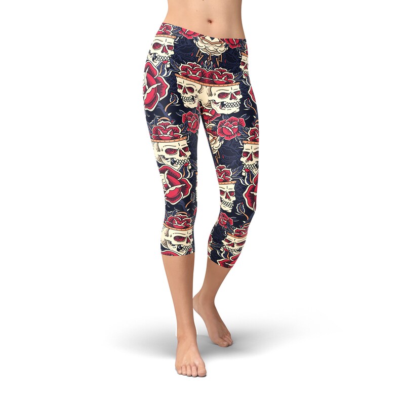 May include: Black leggings with a skull and rose pattern. The skulls are white with black eyes and are surrounded by red roses.