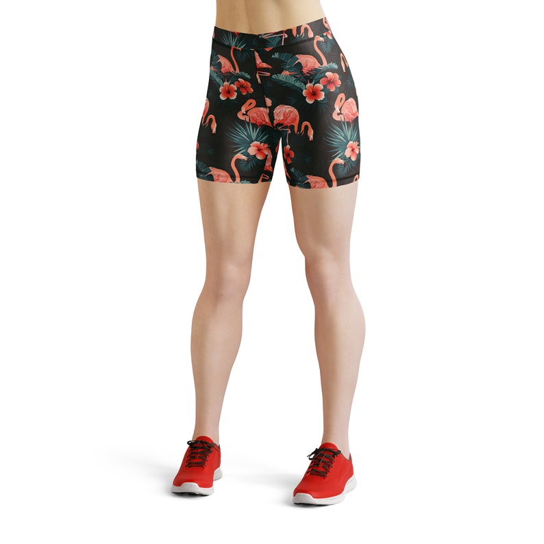 May include: Black athletic shorts with a tropical print featuring pink flamingos and green leaves.
