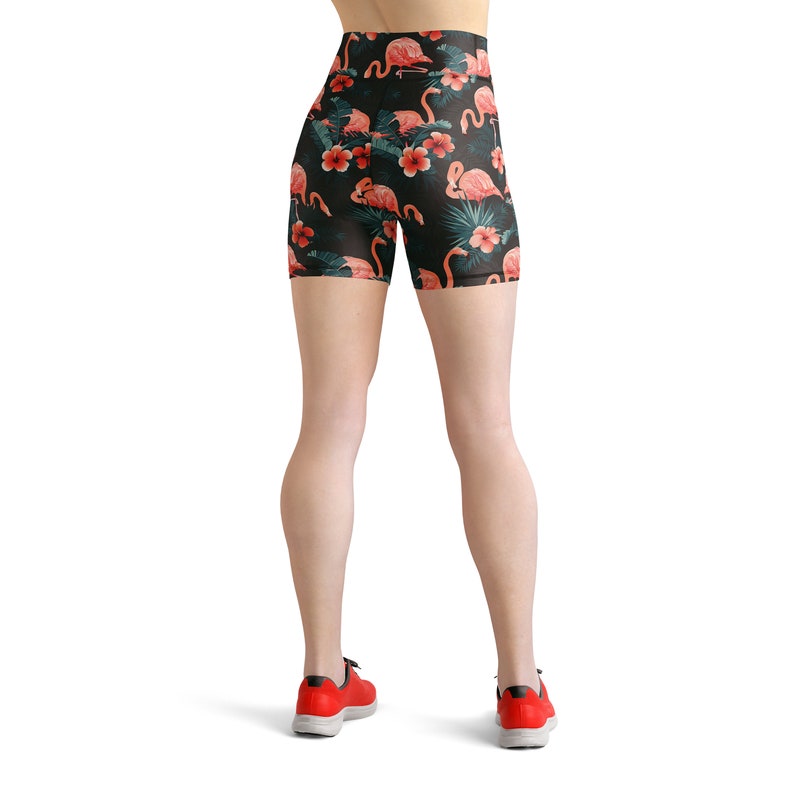 May include: Black athletic shorts with a tropical print featuring pink flamingos and green leaves.