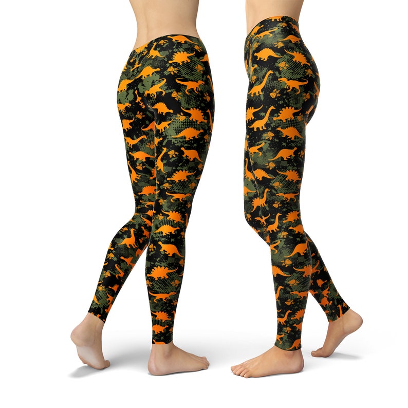 May include: Black leggings with a camouflage pattern featuring orange dinosaur silhouettes.