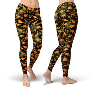 May include: Black leggings with a camouflage pattern featuring orange dinosaur silhouettes.