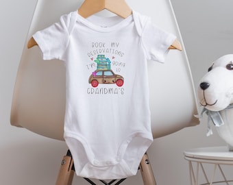 Könnte beinhalten: Weißer Baby-Strampler mit einem Cartoon-Auto, das Gepäck transportiert, und dem Text "Book my reservations I'm going to Grandma's".