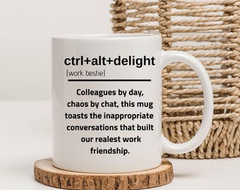 May include: White ceramic mug with the text "ctrl+alt+delight (work bestie)" and a message about work friendships. The mug sits on a wooden coaster, with a woven basket in the background.