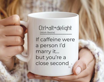 May include: White ceramic mug with the text "Ctrl+alt+delight (Work Bestie)" and the phrase "If caffeine were a person I'd marry it... but you're a close second." The mug has a handle and is held by a person.