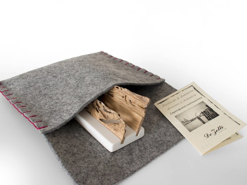 May include: A gray felt pouch with red stitching, containing a wooden sculpture and a certificate of authenticity. The certificate is titled "Certificato di Autentica" and "Diploma of Authenticity" and includes the text "Cerchiudum navticoma" and "De Zolli".