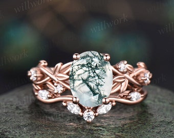 Könnte beinhalten: Verlobungsring aus Roségold mit einem grünen Moosachat-Edelstein und einem filigranen Blattdesign. Der Ring ist mit kleinen Diamanten besetzt.