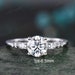 May include: A silver engagement ring with a round centre stone and three pear-shaped accent stones. The centre stone is 1ct-6.5mm.