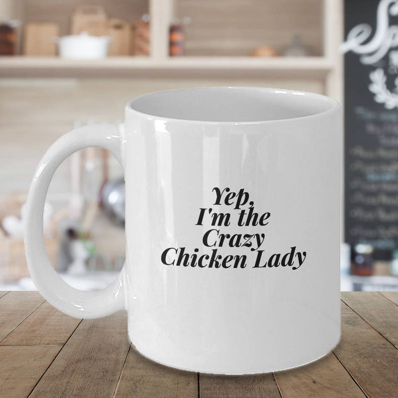 May include: White ceramic coffee mug with a black inscription that reads "Yep, I'm the Crazy Chicken Lady".