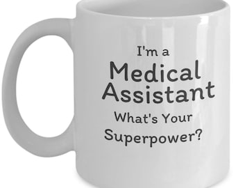May include: White ceramic coffee mug with black text that reads "I'm a Medical Assistant What's Your Superpower?"