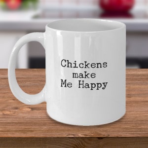 May include: White ceramic coffee mug with black text that reads "Chickens make Me Happy".
