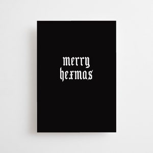 May include: A black rectangular card with the words "merry hermas" in white gothic font. The text is centered on the card. The background is plain white.