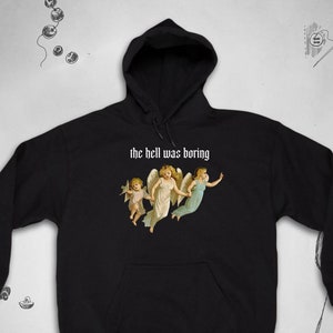 May include: Black hooded sweatshirt with a graphic of three angels and the text "the hell was boring" in white.