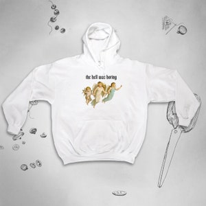 May include: White hoodie with a graphic of three angels and the text "the hell was boring" printed on the front.