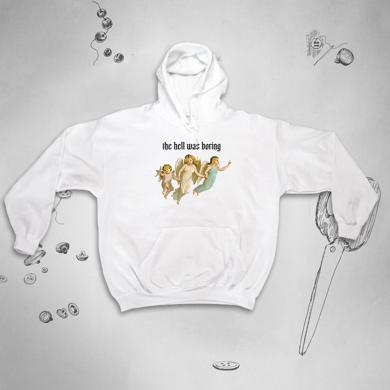 May include: White hoodie with a graphic of three angels and the text "the hell was boring" printed on the front.