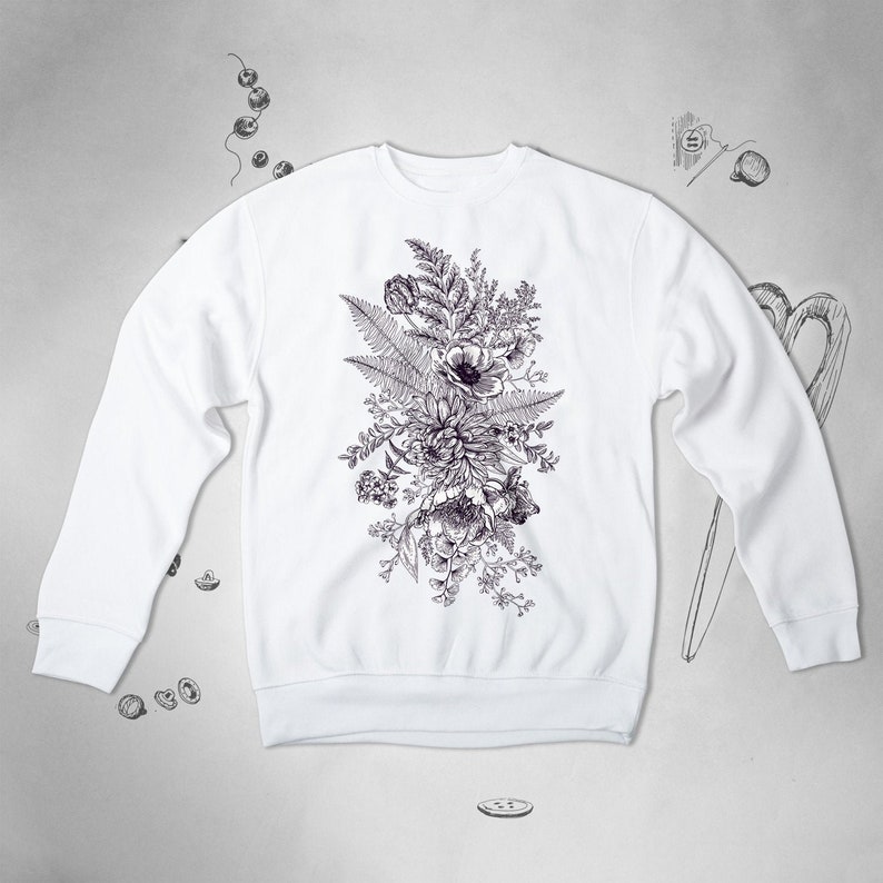 Puede incluir: Sudadera blanca con un dise&ntilde;o de estampado floral en blanco y negro. La impresi&oacute;n presenta un ramo de flores y helechos.