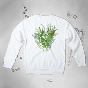 May include: White sweatshirt with a green leafy botanical print on the front.