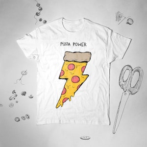 K&ouml;nnte beinhalten: Wei&szlig;es T-Shirt mit einem Grafikdruck eines Pizzast&uuml;cks in Form eines Blitzes. Die Grafik ist gelb mit rotem Pepperoni und der Text "Pizza Power" ist &uuml;ber der Grafik gedruckt.