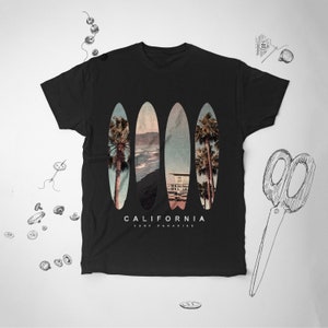 May include: Black t-shirt with a graphic of three surfboards with a beach scene and palm trees. The text "CALIFORNIA SURF PARADISE" is printed below the surfboards.