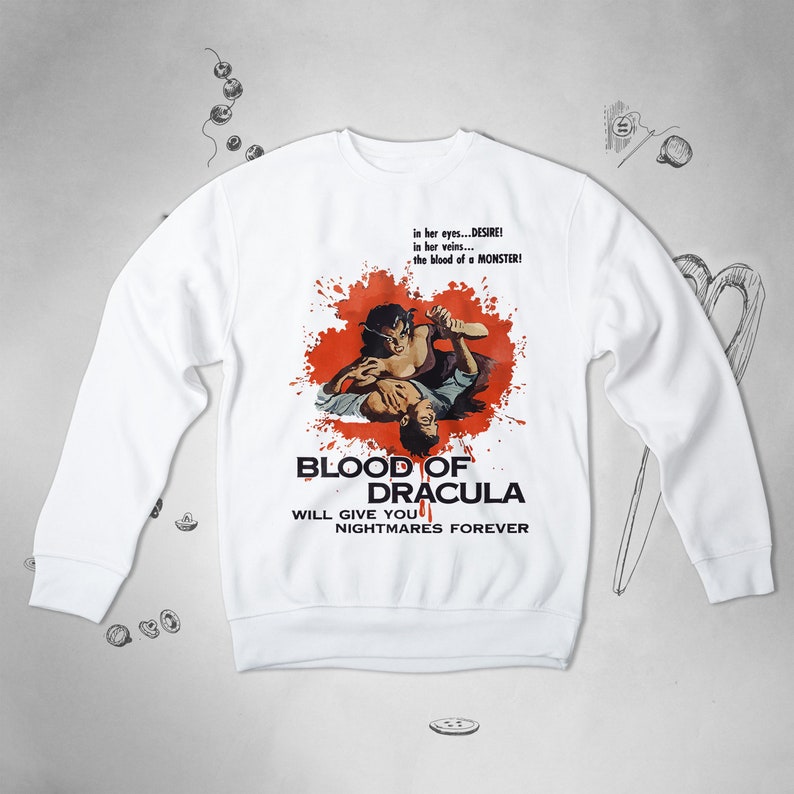 May include: White sweatshirt with a red splatter design and a vintage movie poster graphic. The poster features a couple in a dramatic embrace with the text "Blood of Dracula" and "Will give you nightmares forever".