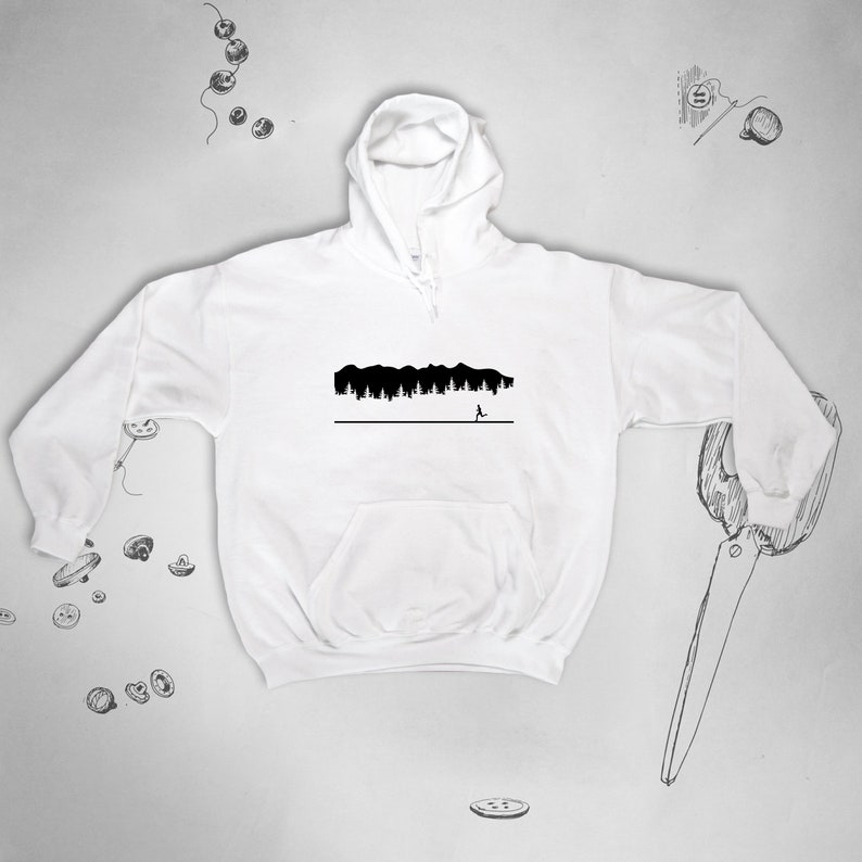 May include: White hooded sweatshirt with a black silhouette of a forest and a person running away from it.
