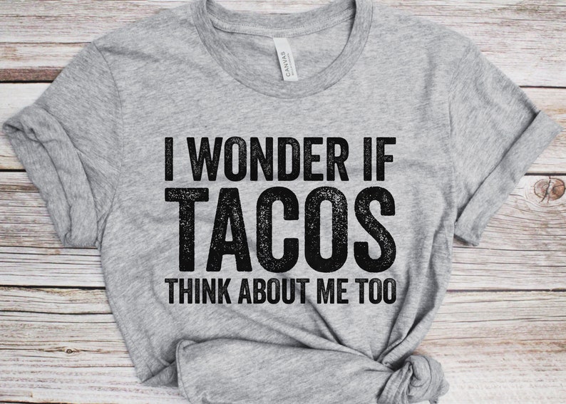 May include: Gray t-shirt with the text "I wonder if tacos think about me too" printed in black.